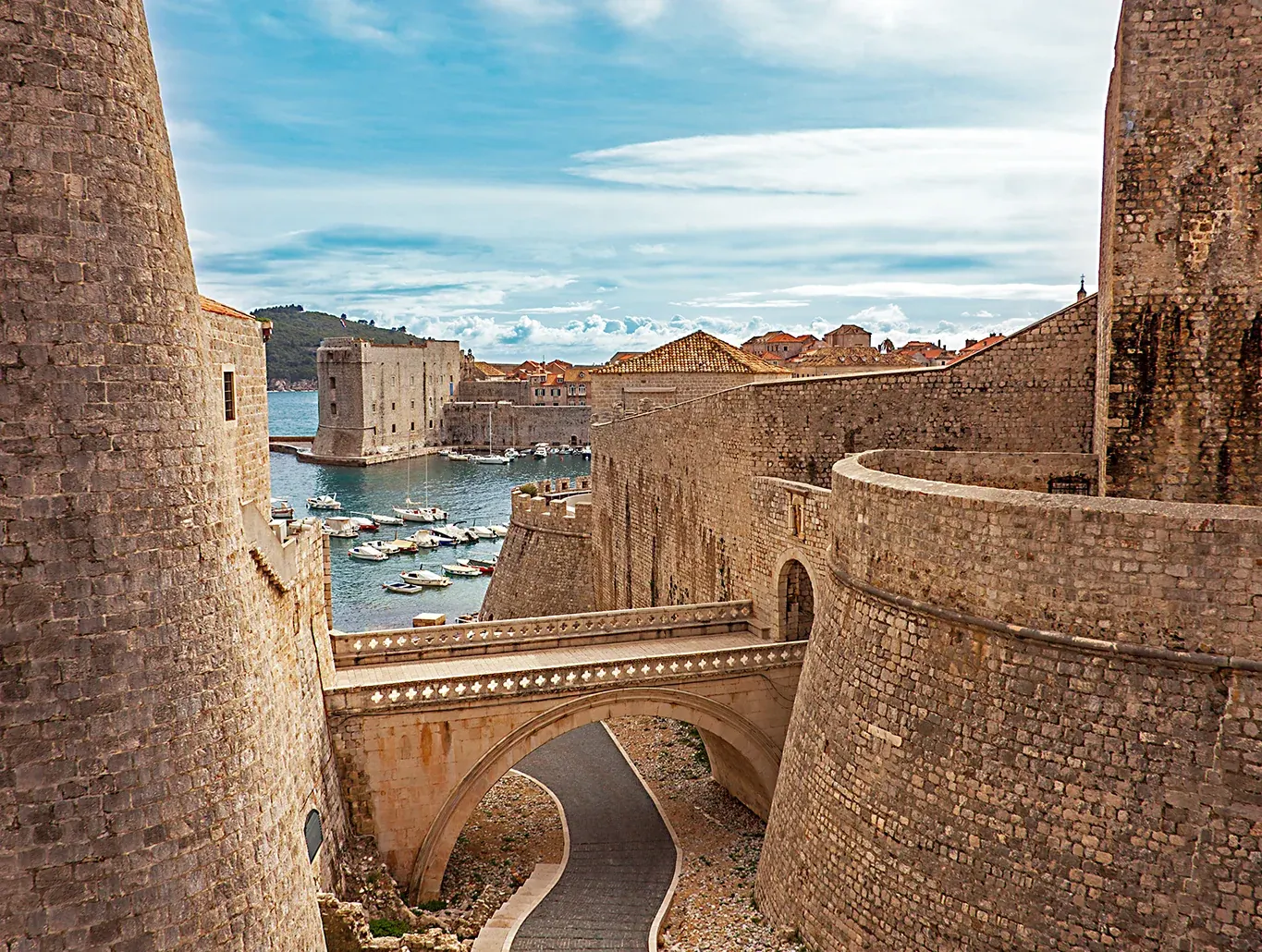 Pogled kroz gradske zidine Dubrovnika prema staroj luci i Jadranskom moru
